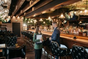Diseño de interiores comerciales en restaurante moderno con mesas iluminadas y ambiente acogedor